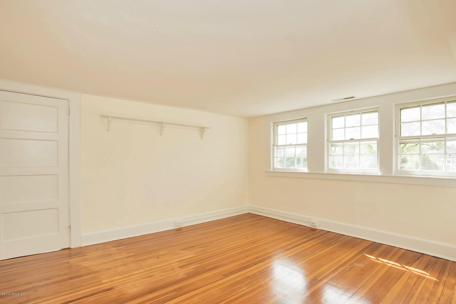 17 Ballwood Road Old Greenwich, CT 06870 - Photo 21 of 36 an empty room with wooden floor and windows