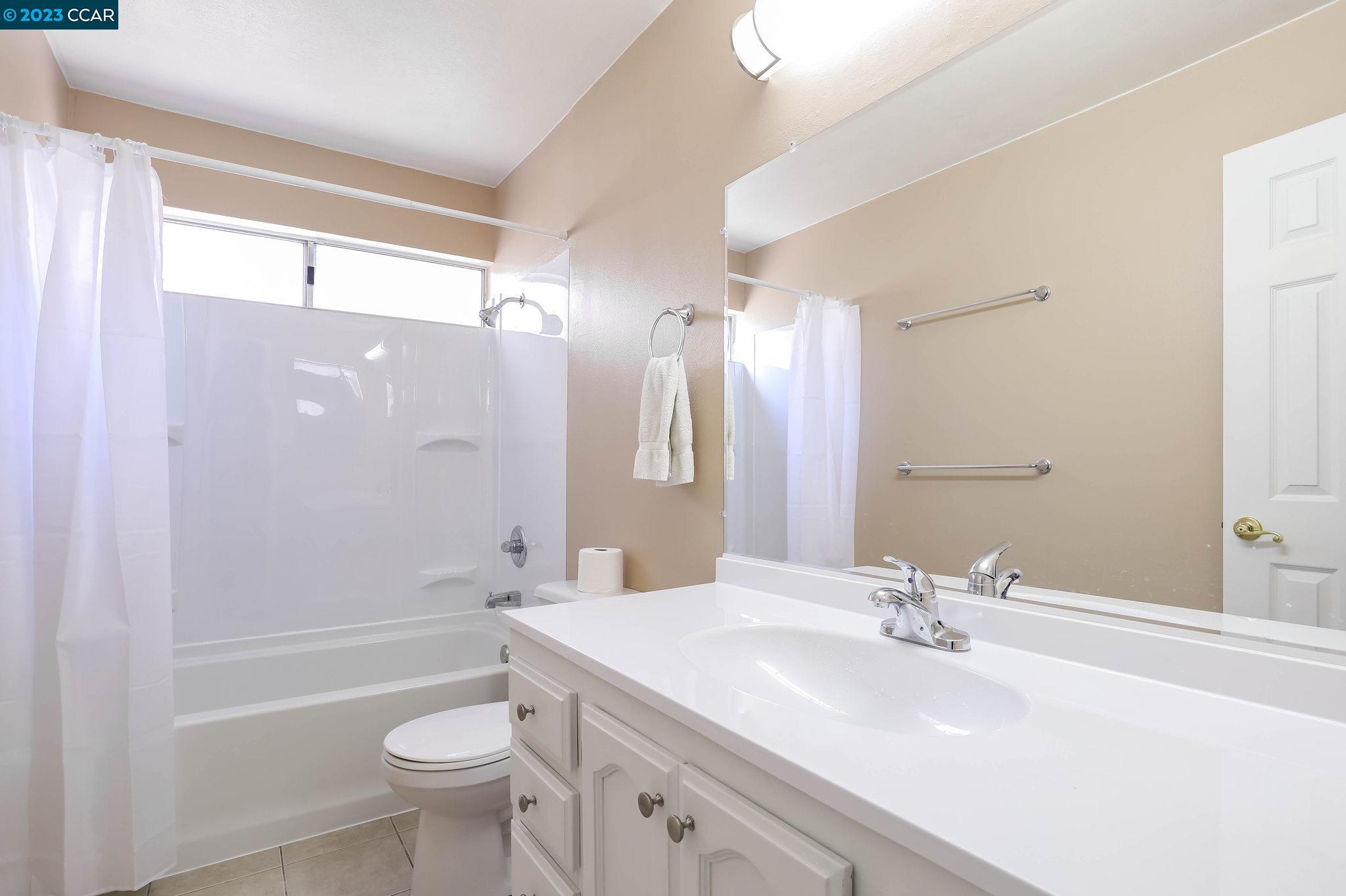 2500 Laguna Circle, Unit C Concord, CA 94520 - Photo 7 of 13 a bathroom with a sink a toilet a mirror a bathtub and shower