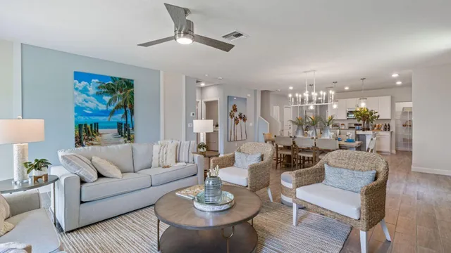 a living room with furniture kitchen view and a chandelier