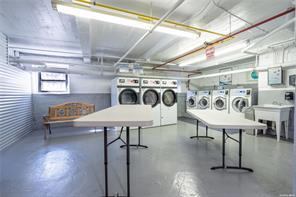 72-34 Austin Street, Unit D4 Queens, NY 11375 - Photo 3 of 3 a utility room with furniture a rug and a chandelier