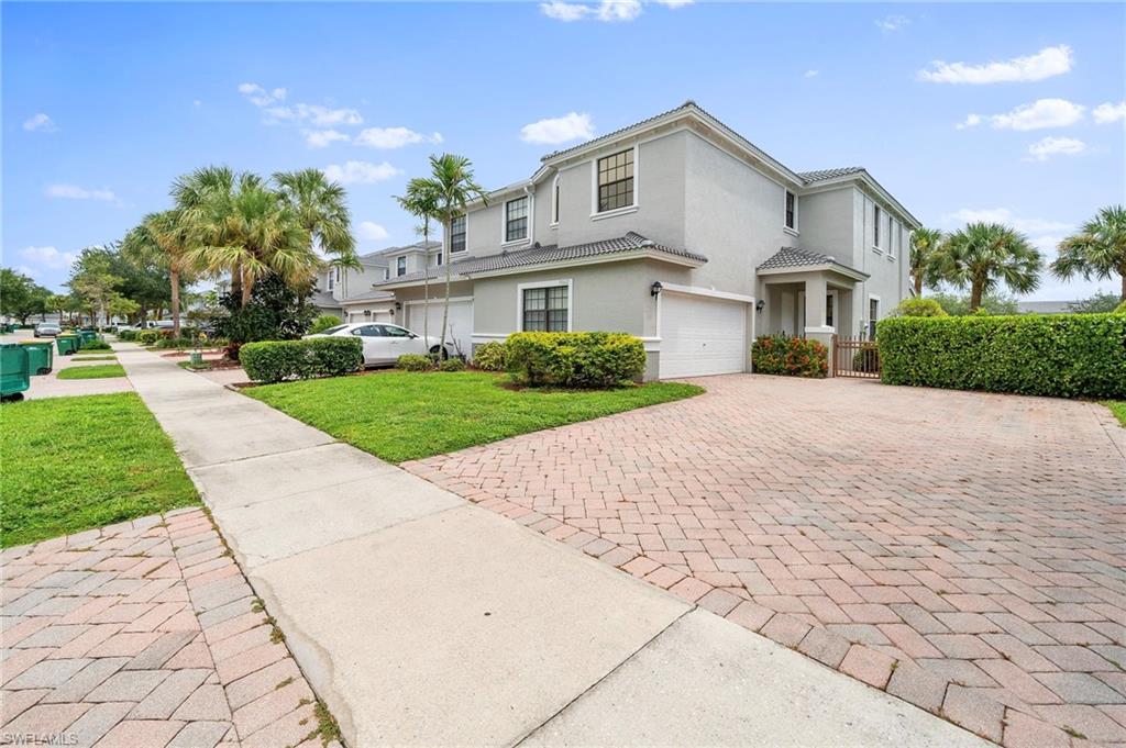 a front view of a house with a yard and potted plants