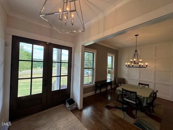 a view of a room with furniture wooden floor and chandelier