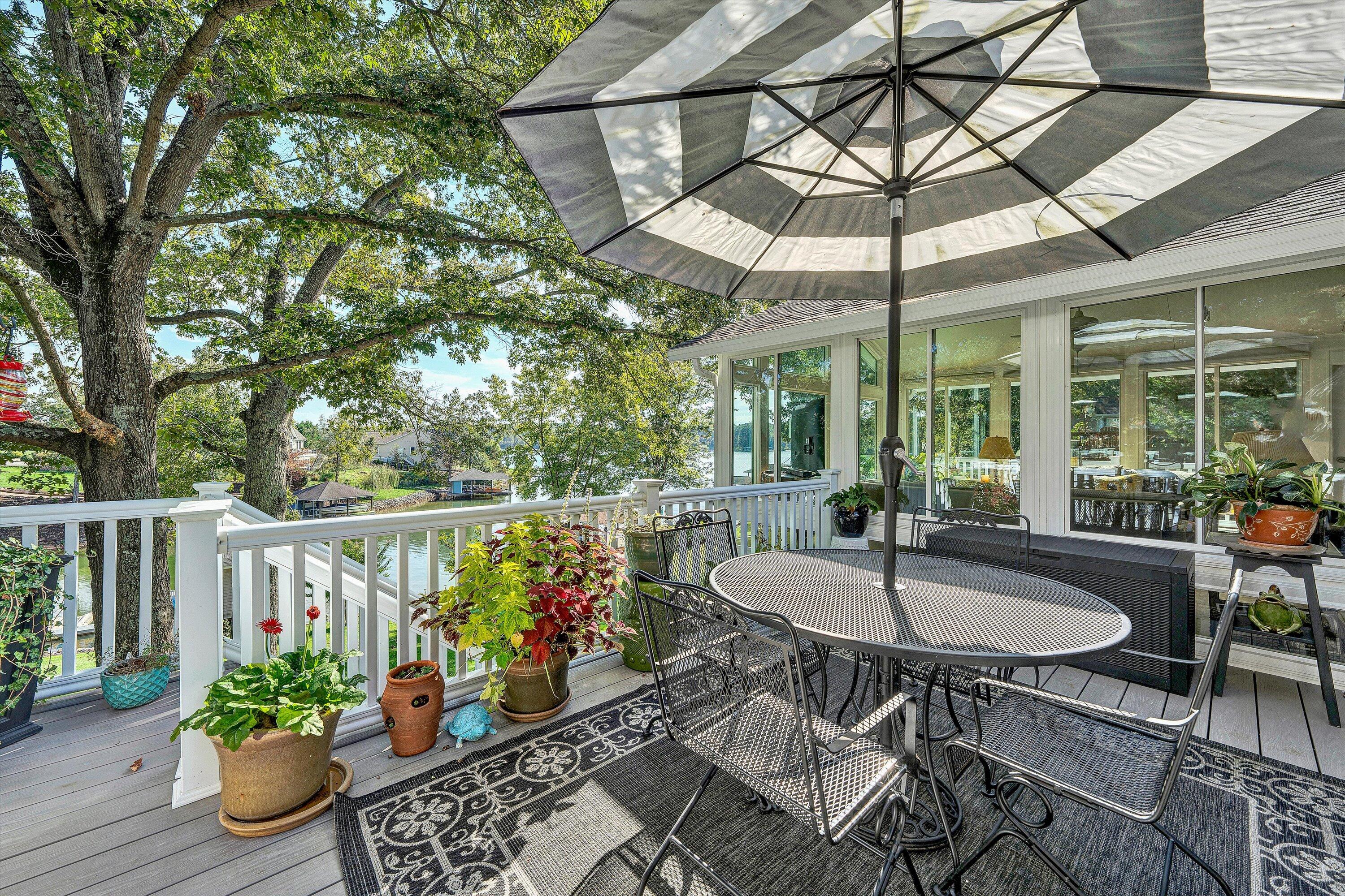 151 Twin Oaks Road Wirtz, VA 24184 - Photo 20 of 41 a view of a patio with table and chairs potted plants and floor to ceiling window