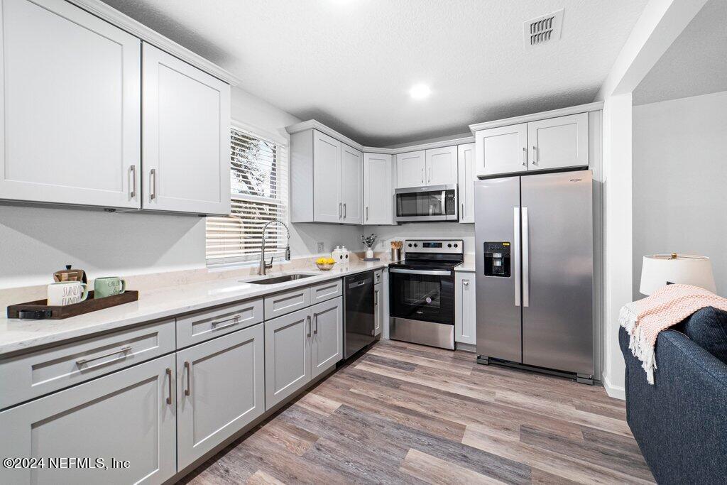 1720 Lilly Road East Jacksonville, FL 32207 - Photo 11 of 33 a kitchen with stainless steel appliances a refrigerator sink and cabinets