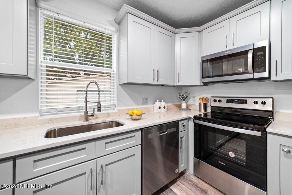 1720 Lilly Road East Jacksonville, FL 32207 - Photo 13 of 33 a kitchen with granite countertop a sink cabinets and stainless steel appliances