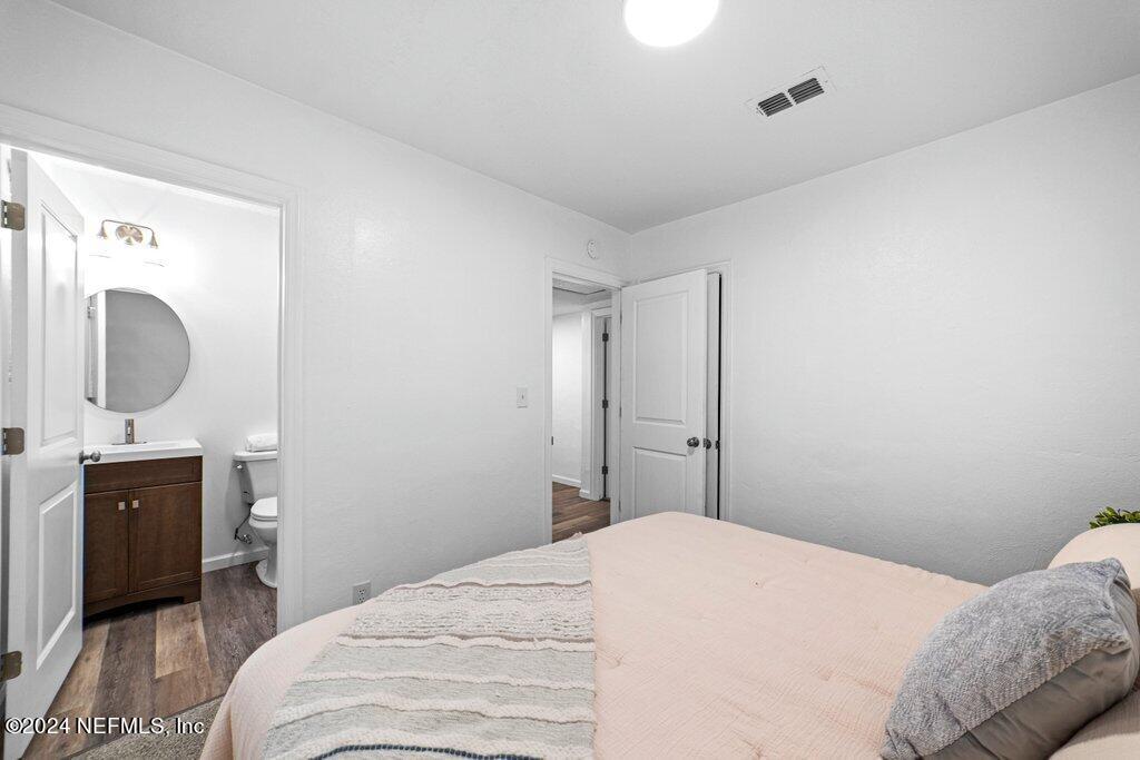 1720 Lilly Road East Jacksonville, FL 32207 - Photo 17 of 33 a bedroom with a bed and a mirror