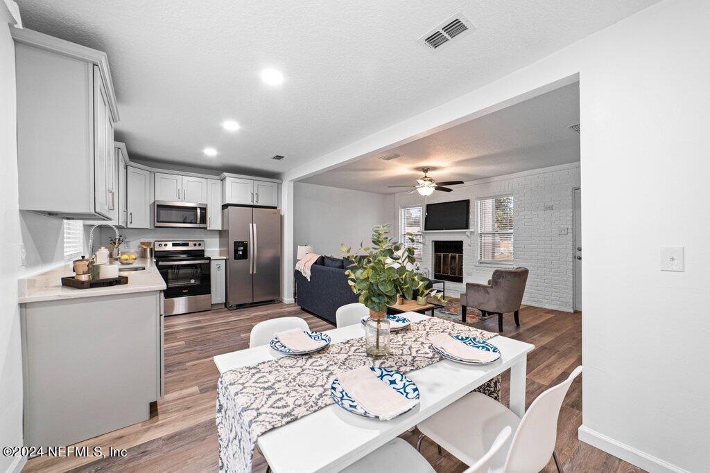 1720 Lilly Road East Jacksonville, FL 32207 - Photo 5 of 33 a kitchen with a refrigerator a stove a dining table and chairs with wooden floor