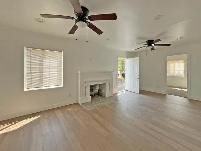 a view of an empty room with a fireplace and a window