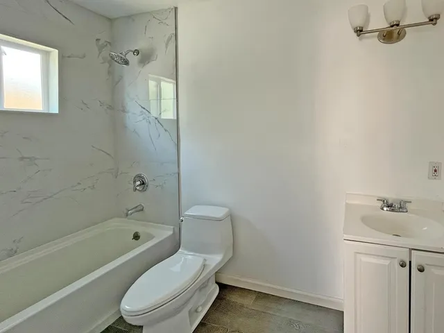 a white toilet sitting next to a bath tub