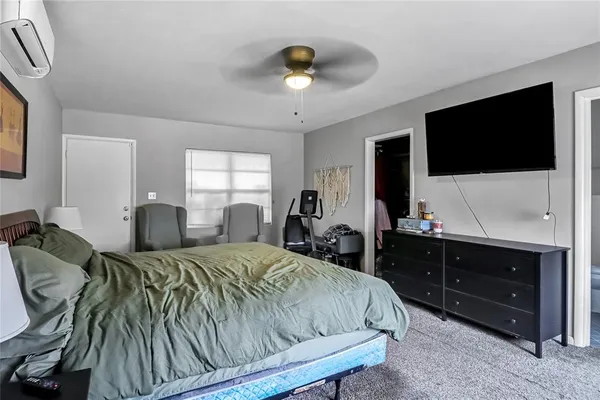 a spacious bedroom with a bed and a flat screen tv