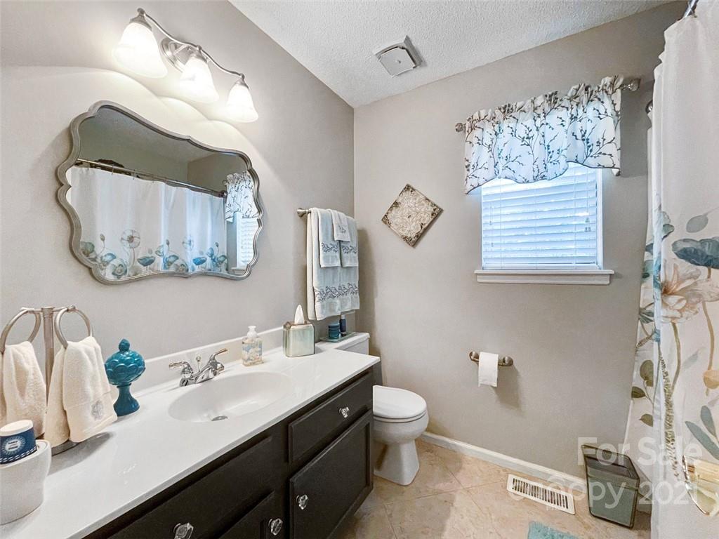 10207 Fairway Ridge Road Charlotte, NC 28277 - Photo 22 of 34 a bathroom with a toilet sink and mirror