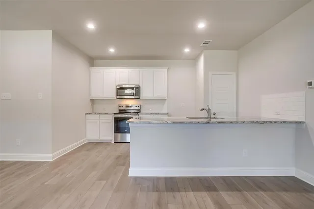 a kitchen with stainless steel appliances granite countertop a stove a sink and a refrigerator