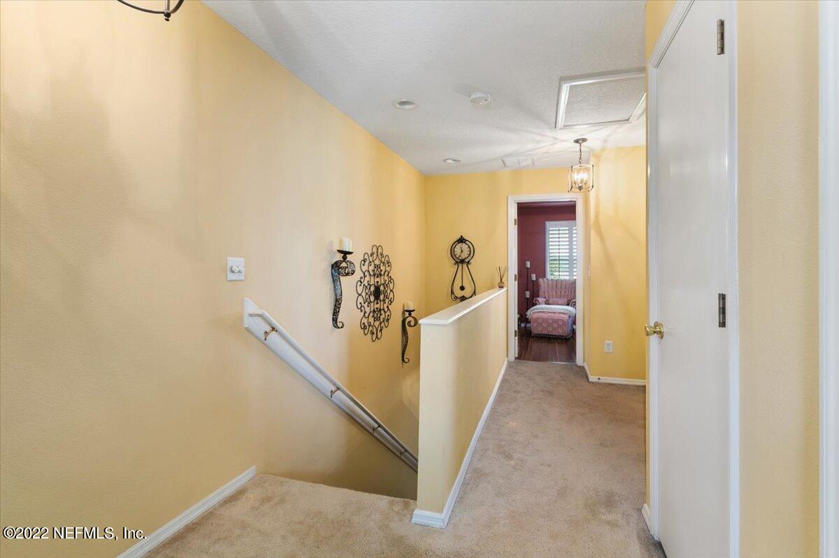 658 Cabernet Place St. Augustine, FL 32084 - Photo 6 of 11 a view of a hallway with white cabinets and a chandelier
