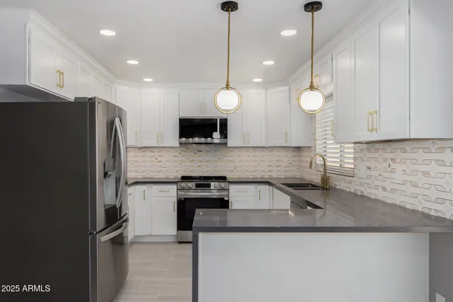 a kitchen with stainless steel appliances granite countertop a sink a stove and a refrigerator