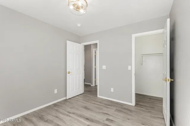 an empty room with wooden floor and window