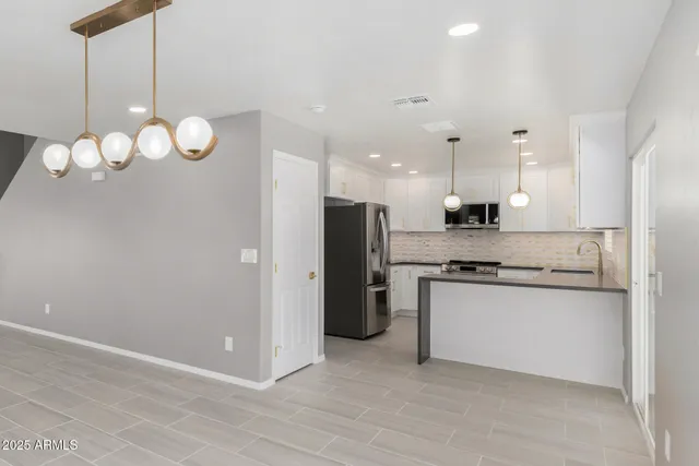 a kitchen with stainless steel appliances kitchen island a refrigerator and a stove top oven