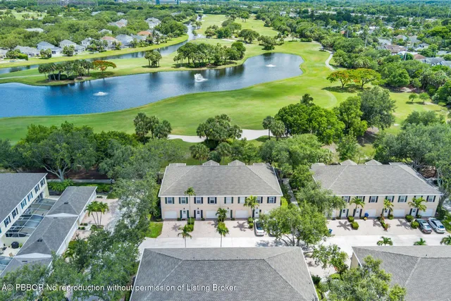 an aerial view of a house with a garden and lake view