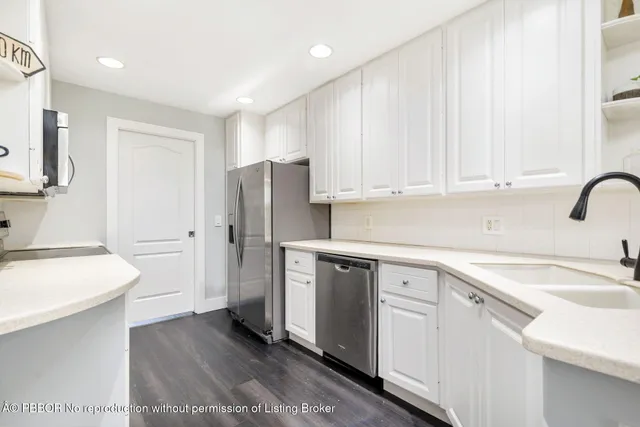 a kitchen with stainless steel appliances granite countertop a refrigerator sink and white cabinets