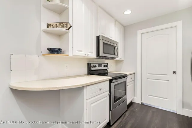 a kitchen with stainless steel appliances a stove microwave and sink