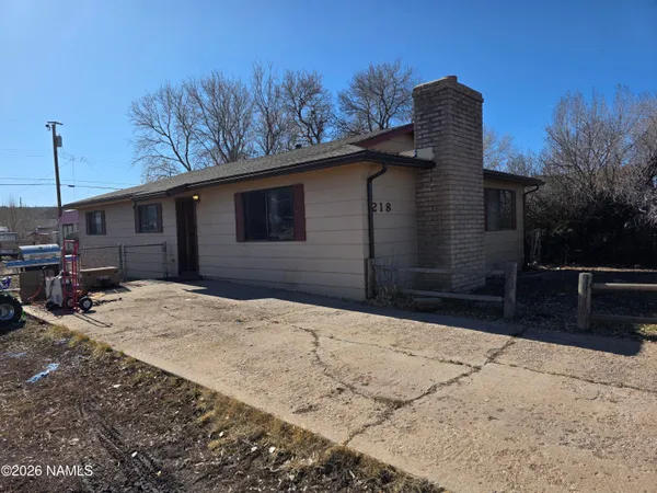 a backyard of a house with wooden fence and trees