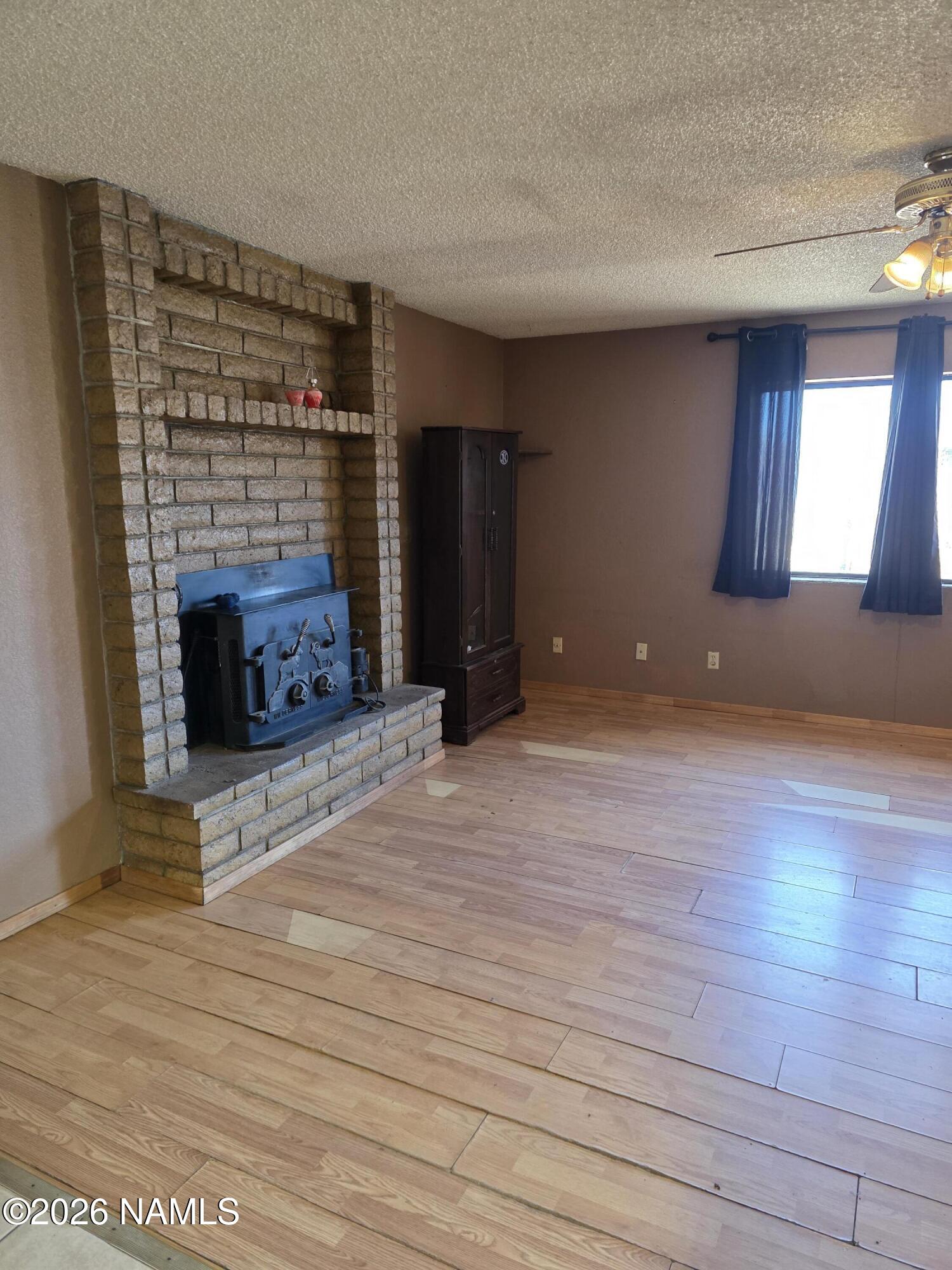 218 East Edison Avenue Williams, AZ 86046 - Photo 15 of 29 an empty room with wooden floor and fireplace