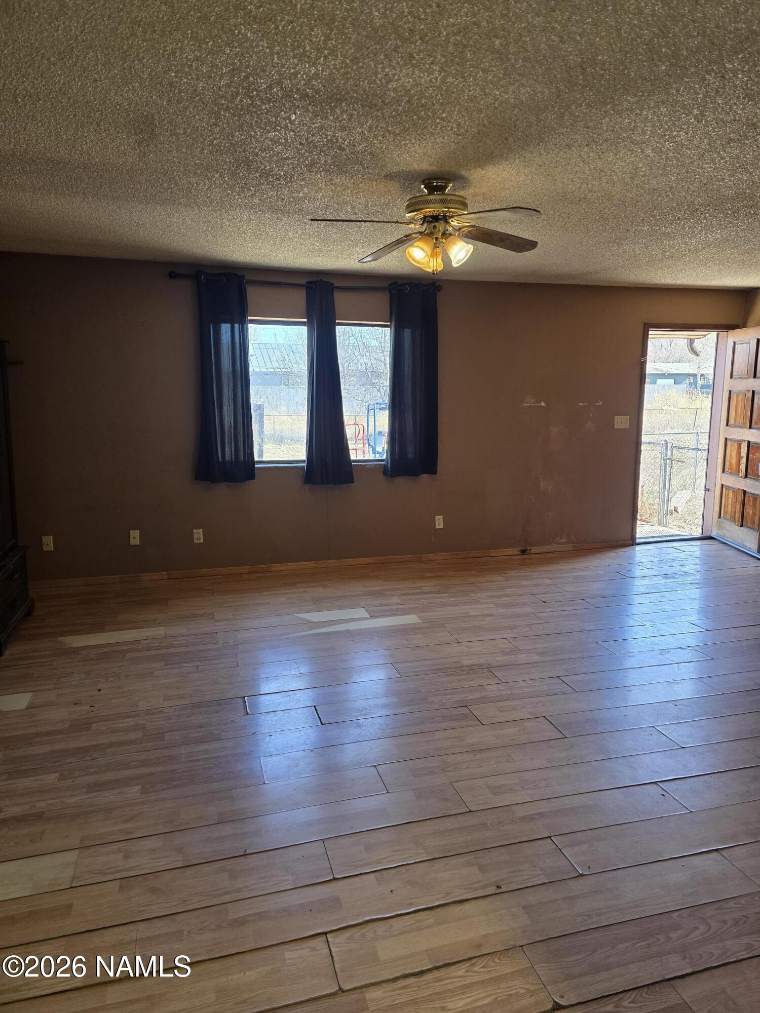218 East Edison Avenue Williams, AZ 86046 - Photo 16 of 29 a view of an empty room with window and wooden floor