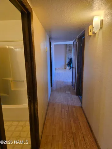 a view of a hallway with wooden floor