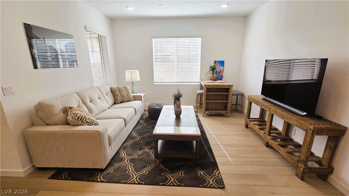 509 Arthur Pointe Street Henderson, NV 89011 - Photo 8 of 12 Streamlined living room with warm wood flooring and recessed lighting.