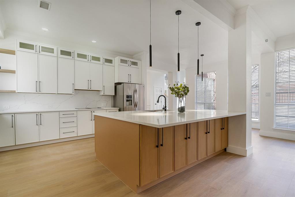 7524 Aberdon Road Dallas, TX 75252 - Photo 1 of 39 Kitchen featuring open shelves, visible vents, decorative backsplash, light wood-type flooring, and stainless steel fridge
