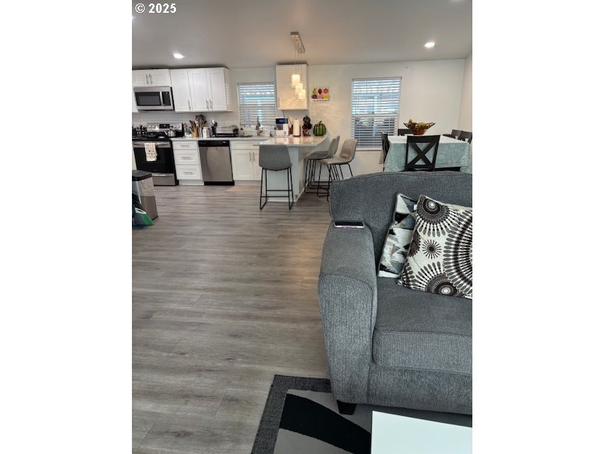 5200 Southeast 132nd Avenue, Unit 12 Portland, OR 97236 - Photo 2 of 17 a living room with couches and kitchen view with wooden floor