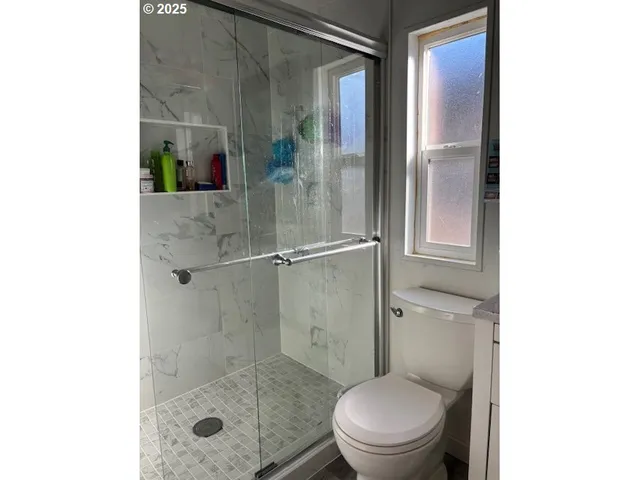 a bathroom with a toilet and a shower