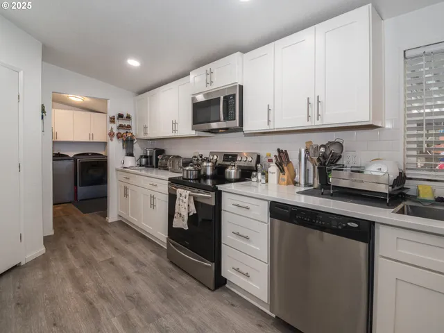 a kitchen with white cabinets sink and stainless steel appliances