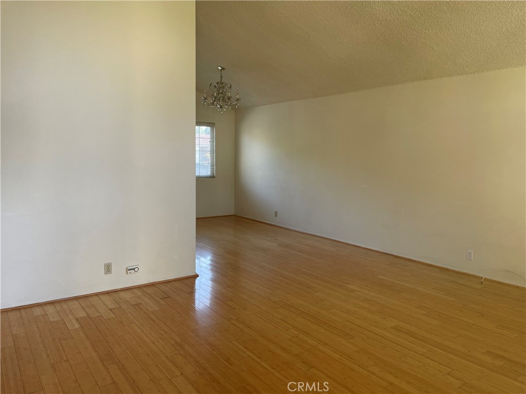 12418 Pine Creek Road Cerritos, CA 90703 - Photo 2 of 7 an empty room with wooden floor and windows
