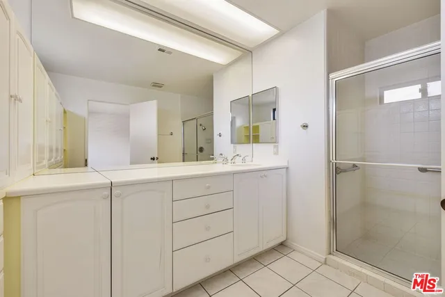 a bathroom with a shower sink and mirror