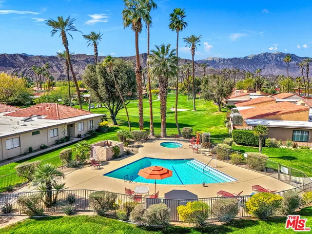 a view of a city with lawn chairs under an umbrella