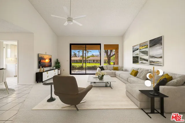 a living room with furniture a flat screen tv and a large window