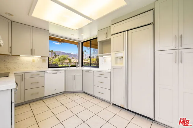 a kitchen with white cabinets and white appliances