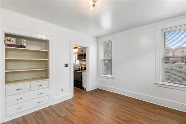 a view of an empty room with cabinet and a window