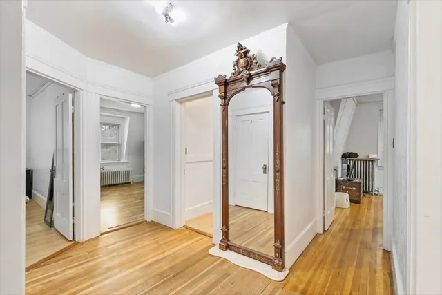 a view of a hallway with wooden floor and staircase