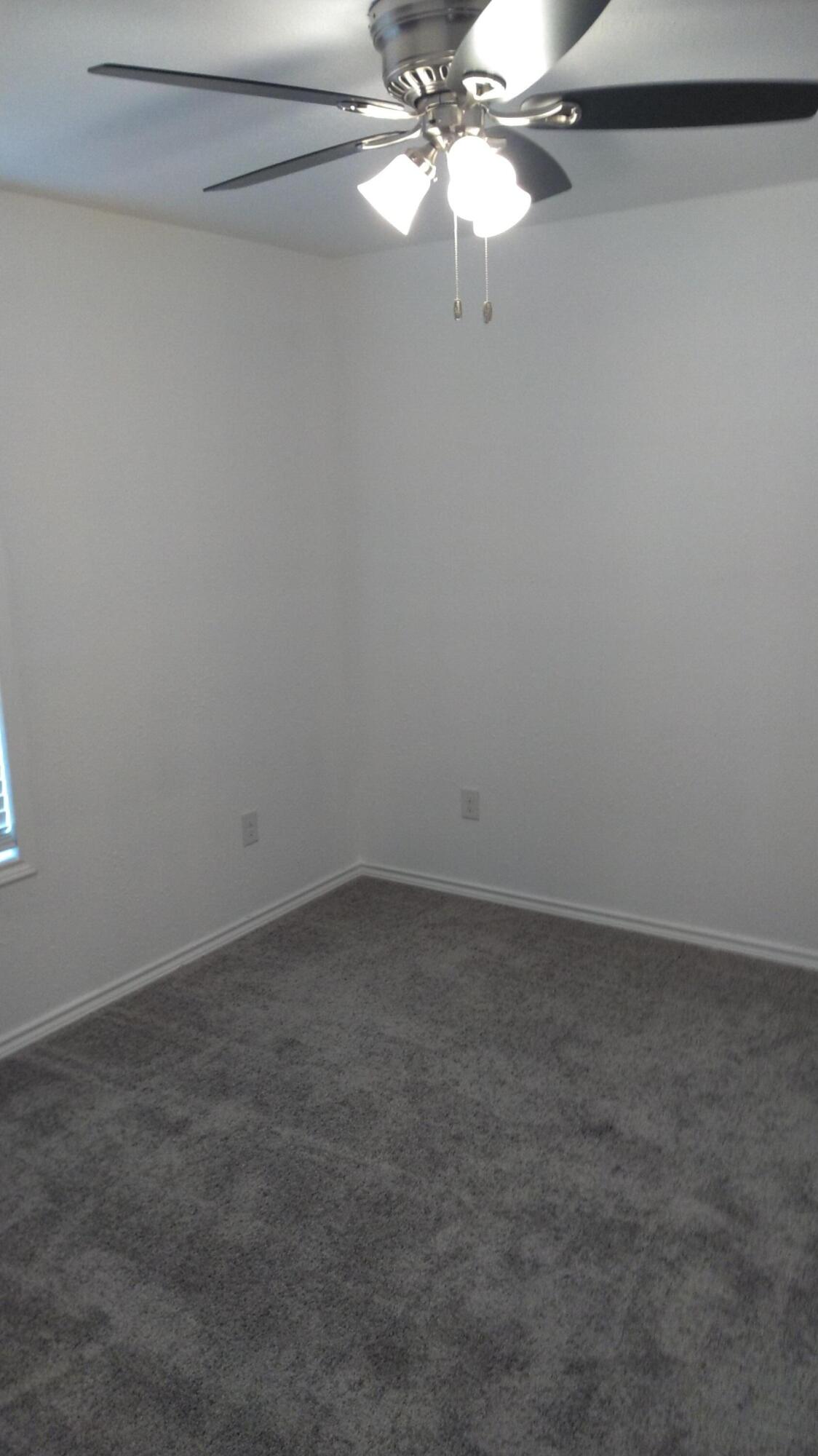 1101 14th Street Abernathy, TX 79311 - Photo 12 of 19 a view of an empty room with a fan