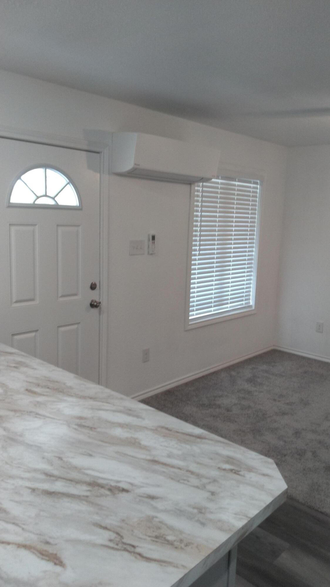 1101 14th Street Abernathy, TX 79311 - Photo 2 of 19 an empty room with wooden floor and windows