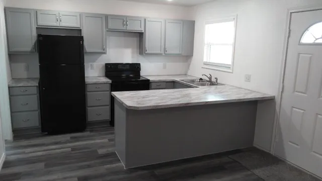 a kitchen with granite countertop a sink stove and refrigerator