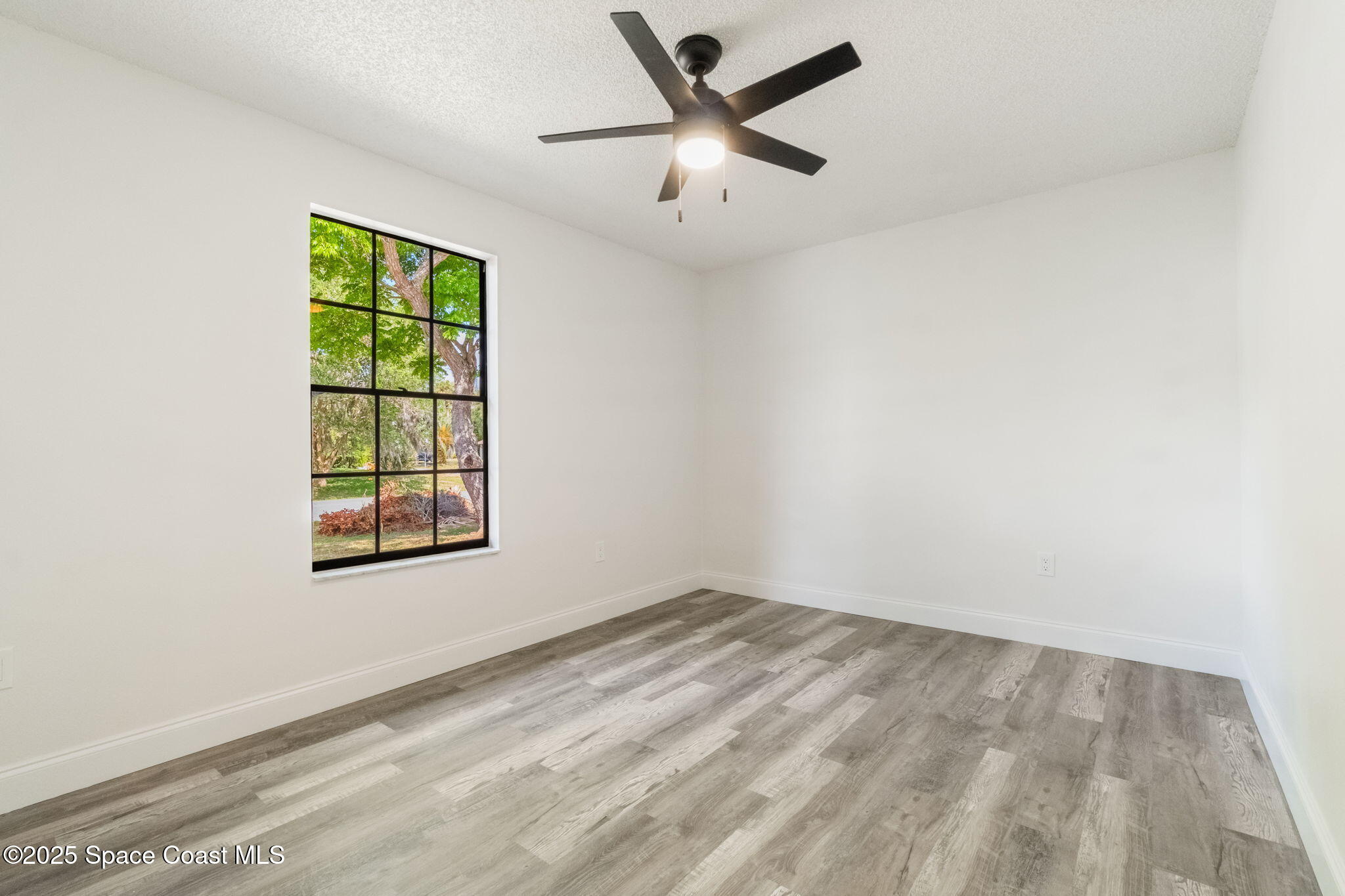 7115 Camilo Road Cocoa, FL 32927 - Photo 13 of 25 an empty room with a window and a ceiling fan