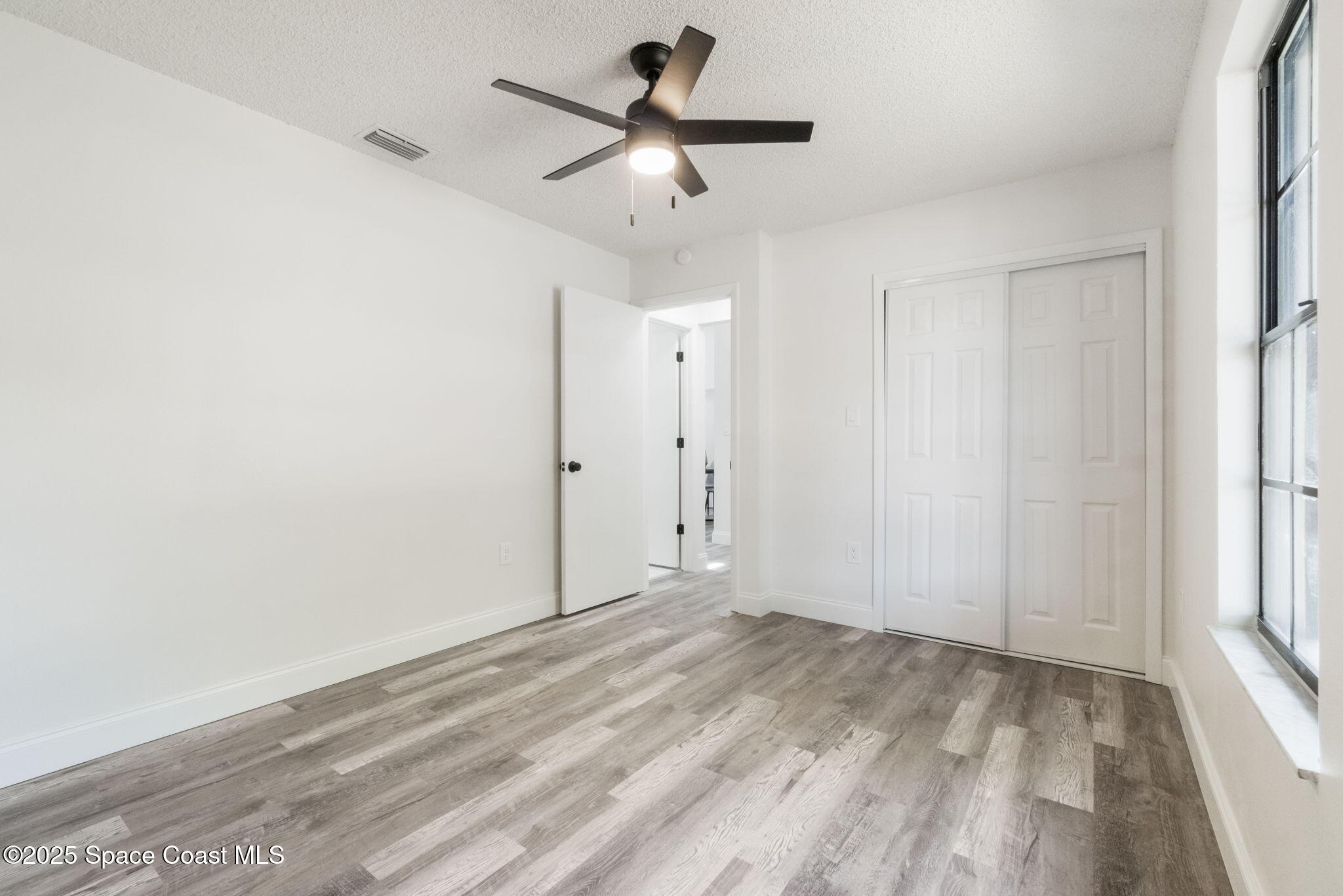 7115 Camilo Road Cocoa, FL 32927 - Photo 14 of 25 a view of a livingroom with a ceiling fan window and hardwood floor