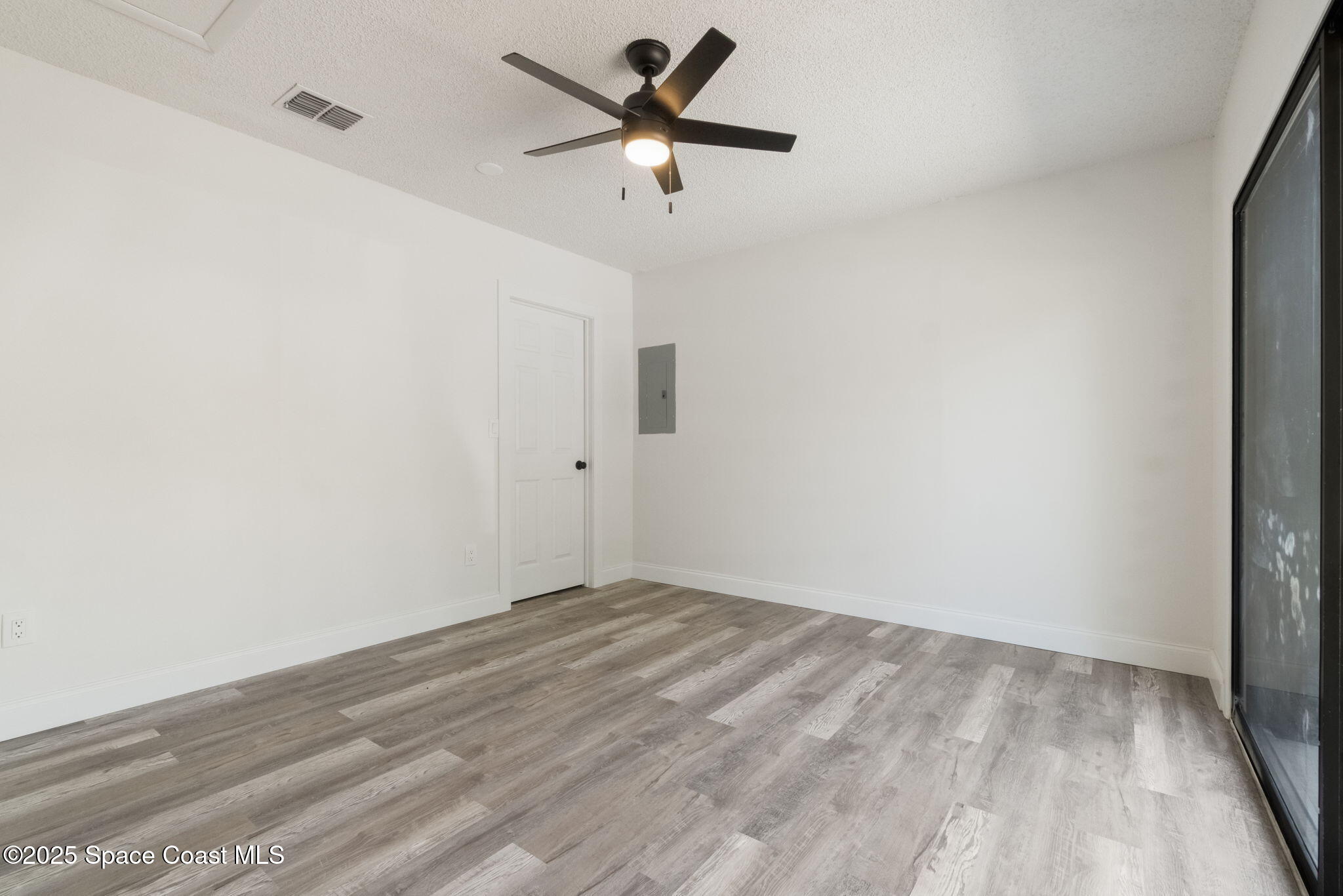 7115 Camilo Road Cocoa, FL 32927 - Photo 15 of 25 a view of room with a ceiling fan and wooden floor