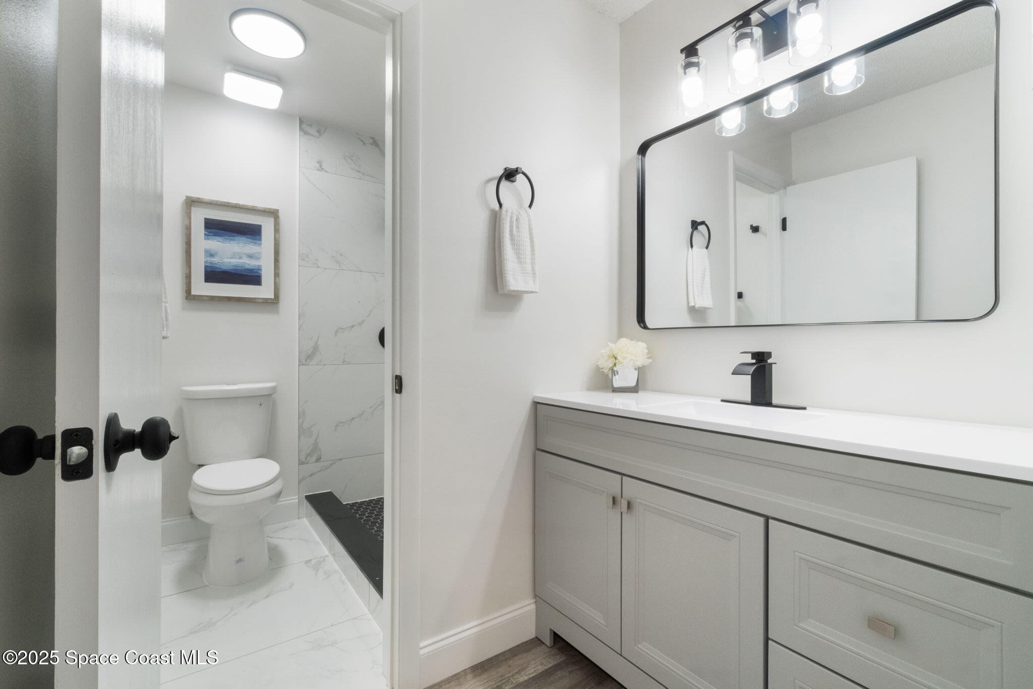 7115 Camilo Road Cocoa, FL 32927 - Photo 19 of 25 a bathroom with a sink a toilet and a mirror