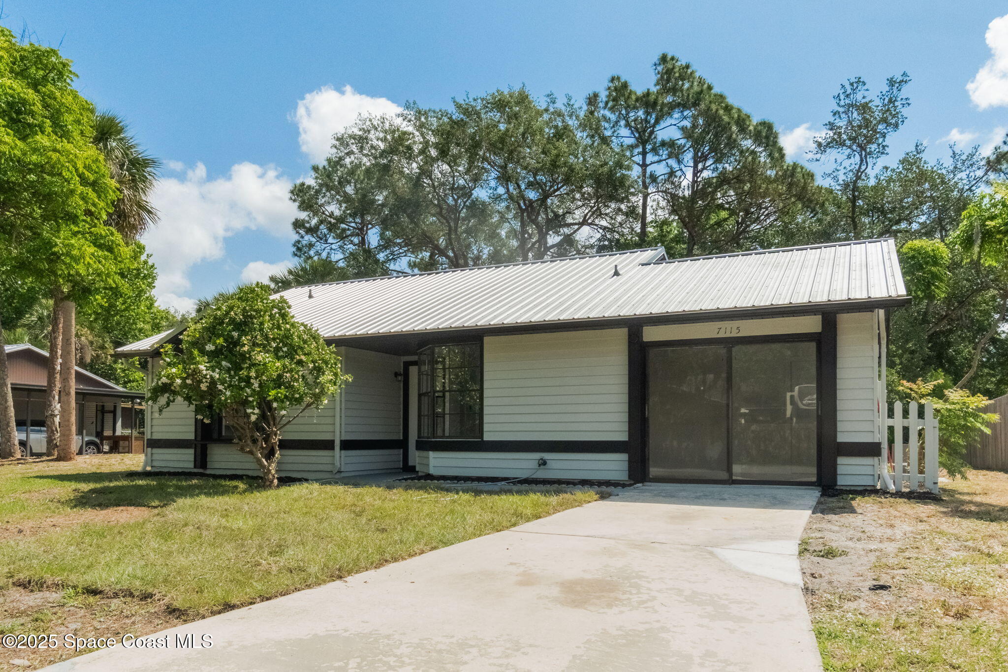 7115 Camilo Road Cocoa, FL 32927 - Photo 2 of 25 a house with trees in the background