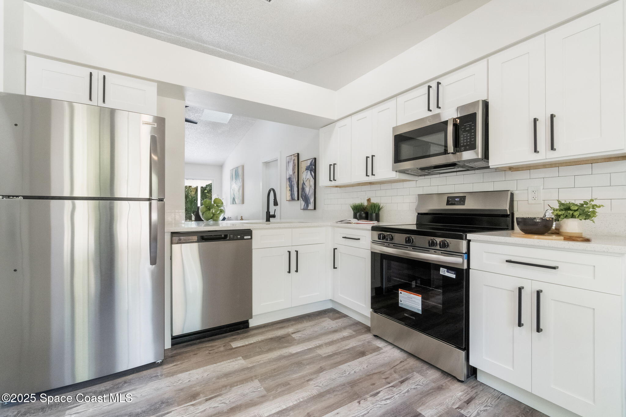 7115 Camilo Road Cocoa, FL 32927 - Photo 8 of 25 a kitchen with white cabinets and white appliances