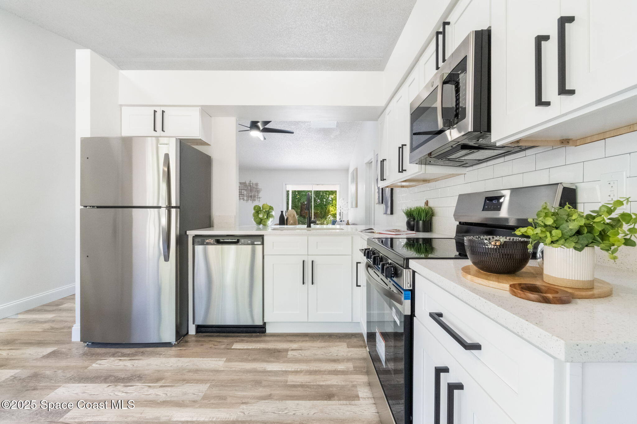 7115 Camilo Road Cocoa, FL 32927 - Photo 10 of 25 a kitchen with a refrigerator and a white cabinets