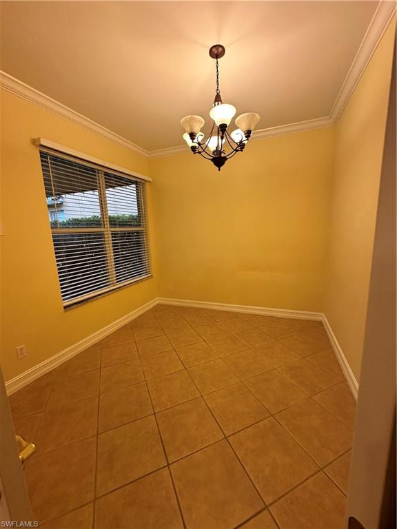 8267 Laurel Lakes Way Naples, FL 34119 - Photo 13 of 23 Spare room featuring ornamental molding, light tile patterned floors, and a chandelier